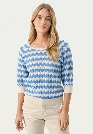 Blauwe en crème gestreepte trui met een golvend patroon, gebreide textuur, ronde halslijn en driekwartmouwen, gecombineerd met beige broek.