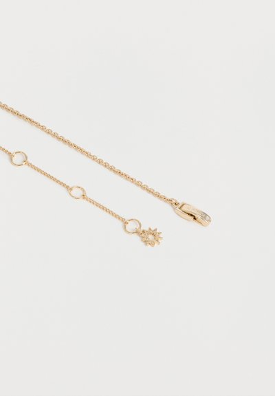 Λεπτό χρυσό κολιέ με μικρό μενταγιόν σε σχήμα αστεριού και κυκλικούς κρίκους, τοποθετημένο επίπεδα σε λευκό φόντο.
