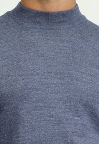 Niebieski sweter z dzianiny z wysokim kołnierzem, o gładkiej fakturze i jednolitym wzorze na całej powierzchni materiału.