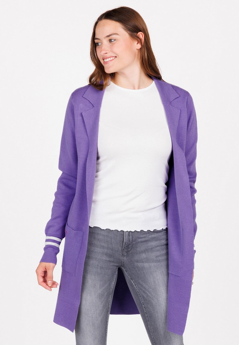 Cardigan largo morado hecho de una tela suave, con un diseño ajustado, frente abierto y dos bolsillos laterales. Con mangas a rayas blancas.
