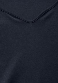 Tessuto di cotone blu navy scuro con una consistenza liscia e una leggera lucentezza. Il scollo presenta un design arrotondato e leggermente sovrapposto.