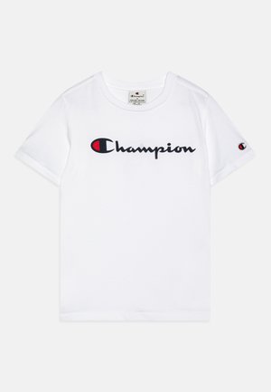 T-shirt bianca a maniche corte con il logo "Champion" in nero e rosso sul petto e un piccolo logo sulla manica sinistra.