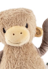 Soft plush monkey toy with tan fur, rounded head, small ears, smiling face, and a brown arm raised, featuring detailed stitching accents.
