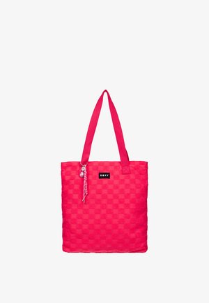 Sac cabas à carreaux rose vif avec deux bretelles, une petite étiquette noire "ROXY" et un porte-clés décoratif tressé.