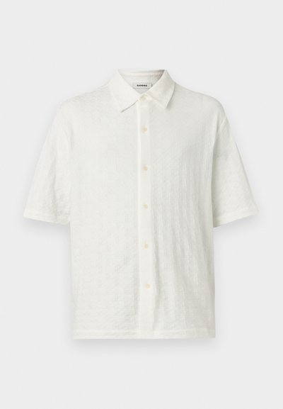 Λευκό πουκάμισο με κοντό μανίκι, διακριτικό υφασμάτινο μοτίβο και κλασικό γιακά, παρουσιάζεται σε ουδέτερο φόντο.