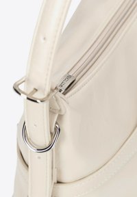 Borsa in pelle sintetica color crema con zip e accessori in argento. Presenta un'ampia apertura, una tracolla con fibbia regolabile e un dettaglio con logo stampato.