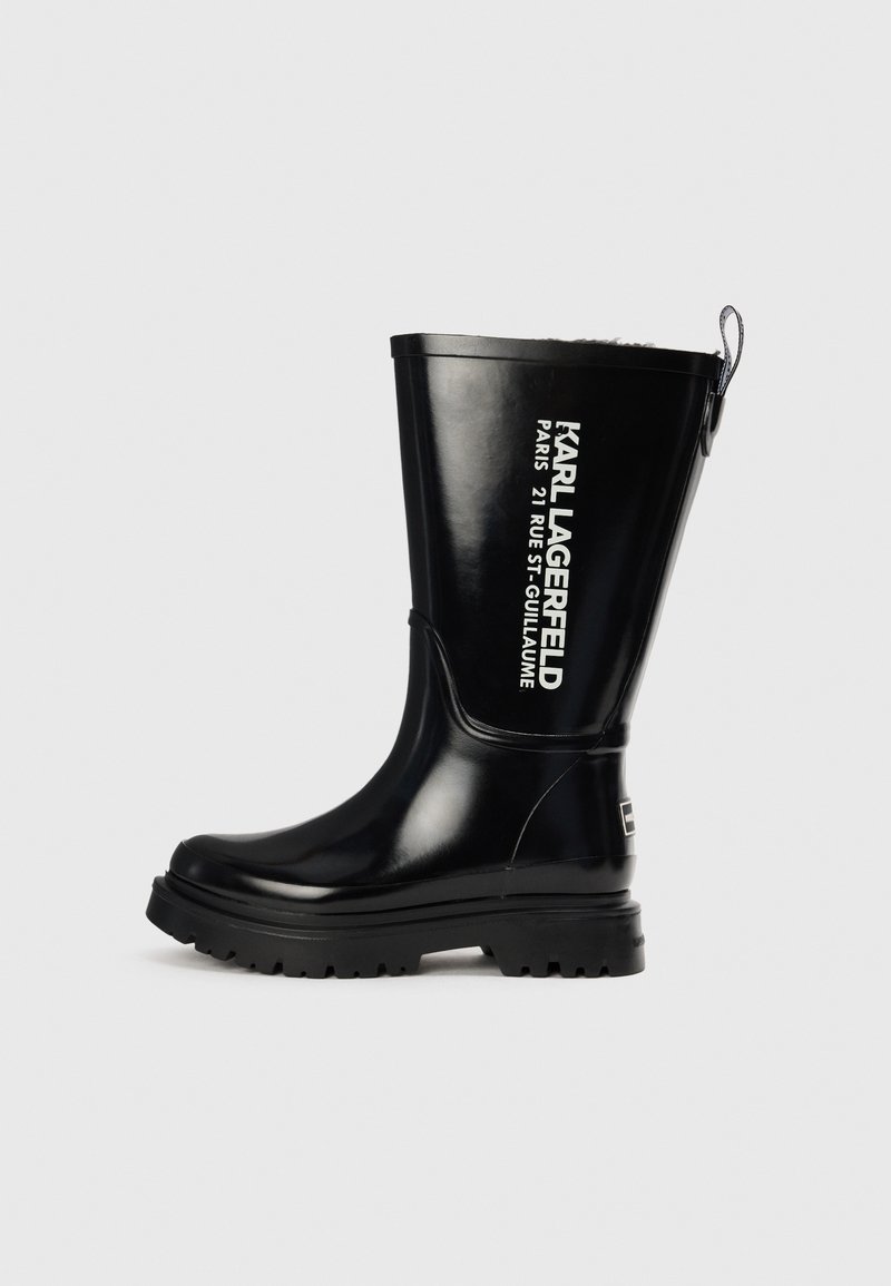 Botte de pluie en caoutchouc noir avec une finition brillante, semelle épaisse et lettrage noir en relief sur le côté. Dispose d'une languette à l'arrière.