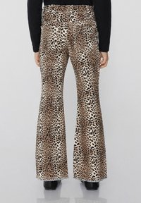 Kalhoty s leopardím potiskem a směsovým bavlněným materiálem. Obsahují béžové a hnědé odstíny, s třepenými lemy a vysokým pasem.