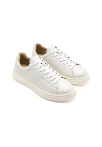 Zapatillas de cuero blanco con punta redonda, cierre de cordones, costuras tonales y una textura suave. Acolchado beige suave con una suela blanca gruesa.