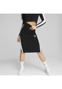 Gonna midi nera con strisce laterali bianche, realizzata in un tessuto elastico. Presenta una vita arricciata e un piccolo logo Puma vicino all'orlo.
