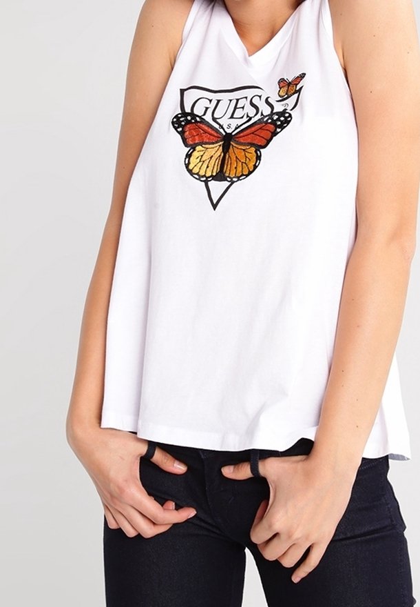 Top sin mangas blanco con un gráfico de mariposa en naranja y negro y el texto "GUESS" debajo, corte relajado, material de algodón suave.