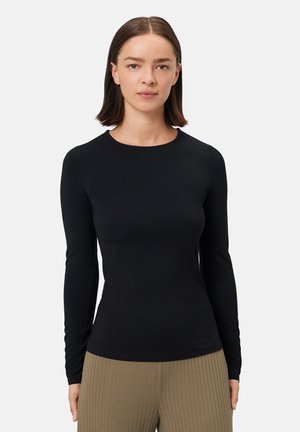 Zwarte longsleeve top gemaakt van een gladde, elastische stof met een ronde halslijn en een aansluitend ontwerp. Gemaakt in combinatie met gestructureerde, geribde beige broek.