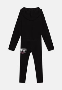 Conjunto de activewear negro de dos piezas que incluye un hoodie corto con capucha y leggings ajustados. Los leggings tienen un gráfico de "BELIEVE" en rosa y plata.