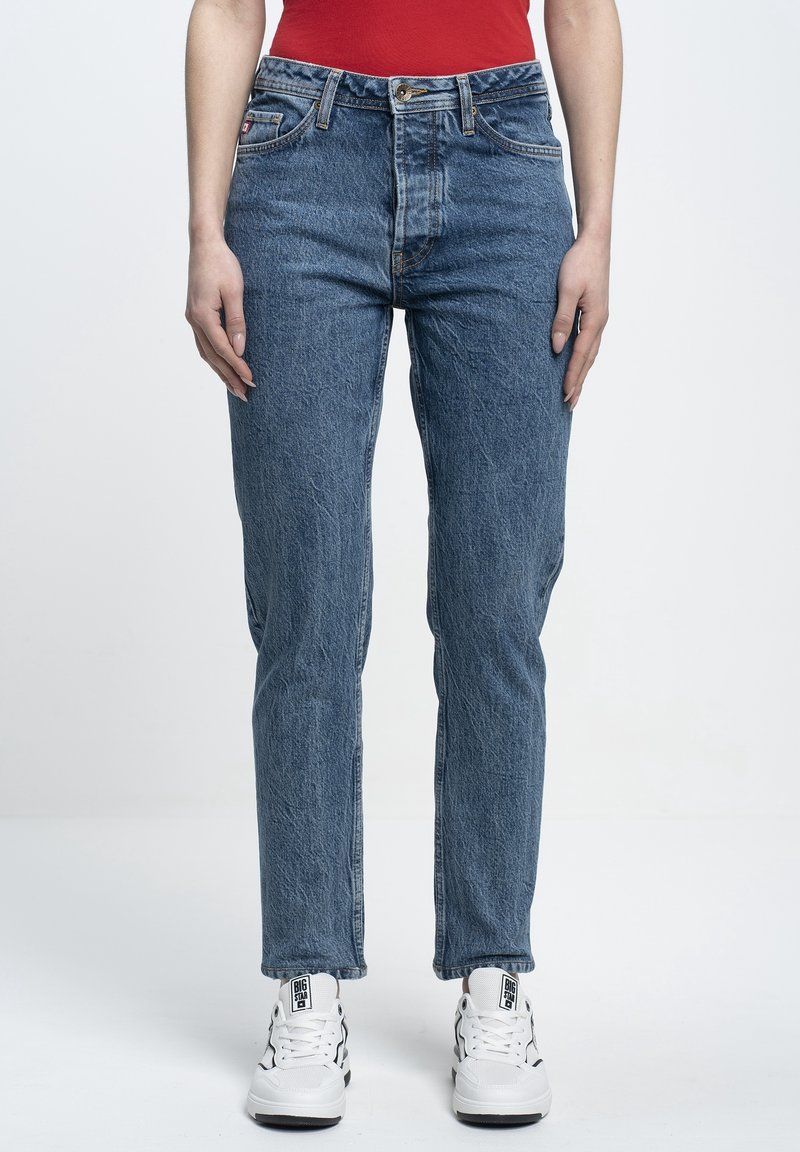 Blue denim jeans with a high waist, straight leg, and slight fading. Worn with white sneakers featuring black accents.