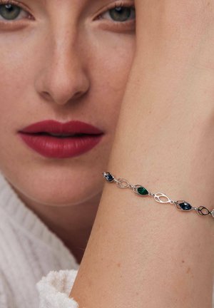 Srebrna bransoletka z owalnymi i marquise'owymi kamieniami w kolorach zielonym, niebieskim i pomarańczowym. Gładka faktura z połączonymi elementami metalowymi.