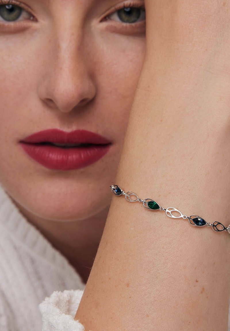 Srebrna bransoletka z owalnymi i marquise'owymi kamieniami w kolorach zielonym, niebieskim i pomarańczowym. Gładka faktura z połączonymi elementami metalowymi.