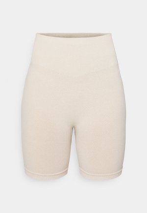 Beige ribbede sykkelshorts med høy midje, med et teksturert mønster og en tettsittende design som strekker seg til midten av låret.