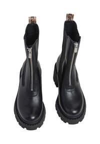 Botas de cuero negras hasta el tobillo con cremalleras dobles, suelas de goma gruesas y una lengüeta en el talón. Presenta un acabado suave y una ligera plataforma.