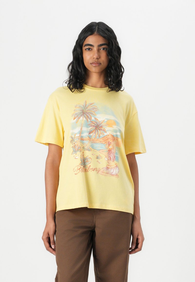 Gul bomullst-shirt med kort ärm som har en strandscen med palmträd och texten "Billabong" i en pastellfärgspalett.