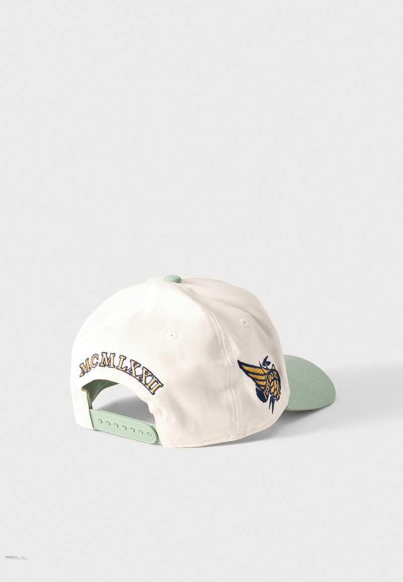 Gorra de béisbol blanca y verde claro con correa ajustable, bordado "MCMLXXII" en la parte trasera y emblema de abeja amarilla y negra en el lateral.