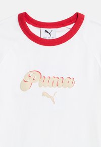 Λευκό πουκάμισο με κόκκινο γιακά που διαθέτε ι ανάγλυφο κρεμ και κόκκινο λογότυπο Puma και έμβλημα με άλτσα γάτα στο κέντρο κάτω από το λαιμό.