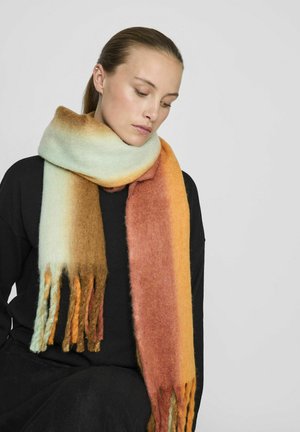 Écharpe en laine présentant des couleurs dégradées allant du bleu clair au brun et à l'orange, avec des extrémités frangées et une apparence douce et texturée.