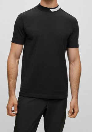 Schwarzes kurzärmeliges T-Shirt mit hohem Kragen und einem weißen Akzentstreifen am Hals. Hergestellt aus weichem, dehnbarem Material.
