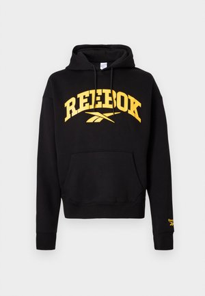 Juodas medvilnės džemperis su gobtuvu, ant krūtinės yra geltona "REEBOK" logotipas, su raišteliu gobtuvu ir priekinėmis kišenėmis. Guma apykaklėse ir apačioje.