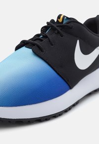 Black and blue athletic shoe with a gradient upper, textured mesh fabric, white Swoosh logo, and a cushioned white sole.