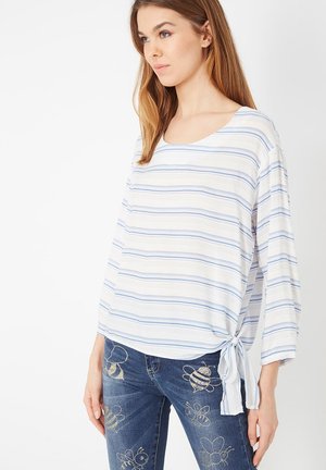 Top a rayas en tela blanca y azul, con un escote amplio, mangas de tres cuartos y un detalle de lazo en la cadera.