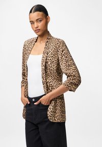 Λεοπάρντ σακάκι με κομψή εφαρμογή, ελαφρύ ύφασμα, ανοιχτό μπροστά και τρία τέταρτα μανίκια, συνδυασμένο με λευκό τοπ και μαύρο παντελόνι.