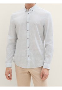Camicia button-up azzurro chiaro con un delicato motivo a quadri, bottoni marroni e colletto, realizzata in un tessuto testurizzato.