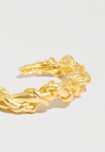 Pulseira torcida em tom dourado com design em nó e superfície lisa e brilhante, destacando detalhes intrincados e ajuste flexível.