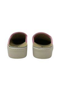 Scarpe slip-on di stoffa rosa con punta arrotondata, suola piatta beige e rivestimento morbido e testurizzato. Design minimalista senza hardware prominente.