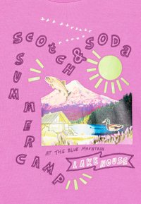 Un tissu rose présente un graphisme avec des montagnes, des arbres, un cabanon, des poissons et un canard. Les éléments de texte mettent en avant "Scotch & Soda", "Camp d'Été" et "Maison au Bord du Lac".