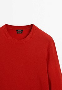 Pull col rond rouge en 100 % cachemire, avec col côtelé et manches longues, présenté à plat sur fond blanc.