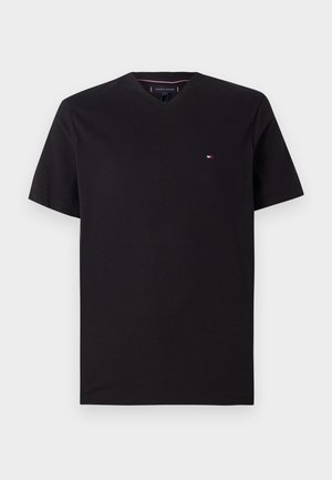 Juoda trumpomis rankovėmis V formos iškirptės marškinėliai su mažomis raudoną, baltą ir mėlyną Tommy Hilfiger logotipu kairėje krūtinės pusėje.