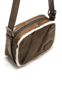 Borsa a tracolla in pelle marrone con rifiniture in pelliccia sintetica crema, chiusura con zip e design texture curvo. Include una tracolla regolabile.