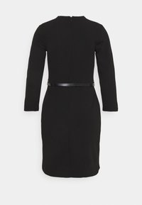 Vestido negro de manga larga con una silueta ajustada, que presenta una tela suave, cierre de cremallera en la parte posterior y un cinturón negro estrecho en la cintura.