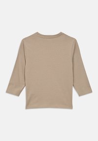 Μπεζ μακρυμάνικη μπλούζα με λαιμόκοψη τύπου crewneck, απλωμένη, εμφανιζόμενη από την πίσω πλευρά, σε λευκό φόντο.