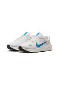 Biele bežecké topánky s textúrovaným zvrškom, s modrým Nike swooshom, svetlomodrými akcentmi na jazyku a čiernou podrážkou.
