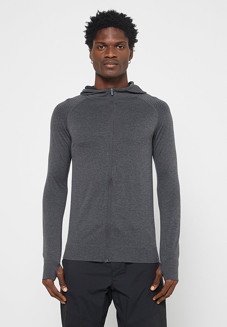 Bluza z kapturem zapinana na zamek w ciemnoszarym kolorze, wykonana z miękkiego materiału z prążkowanymi akcentami i teksturowanymi panelami na ramionach. Długie rękawy z otworami na kciuki.