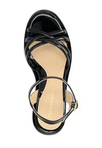 Sandale en cuir verni noir avec des sangles croisées, une boucle à la cheville et une semelle intérieure beige. Texture lisse et design ouvert à l'avant.
