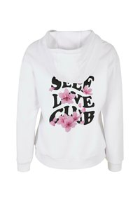 Fehér kapucnis pulóver, amelyen a "SELF LOVE CLUB" szöveg vastag feketén, rózsaszín virágos grafikával van kiemelve az elején. Puha szövettextúra.