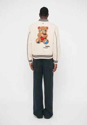 Giacca bomber crema con un grande design del teddy bear ricamato sul retro, con polsini e orlo a coste, e rifiniture nere a contrasto.