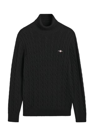 Jersey de cuello alto negro con punto trenzado, que presenta un patrón texturizado, puños y dobladillo acanalados, y un pequeño logotipo bordado en el pecho.