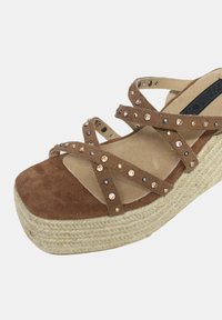 Espadrillas platform in pelle scamosciata marrone con design a fascia incrociata. Parte superiore morbida decorata con strass. Suola intermedia in juta intrecciata. Punta rotonda.