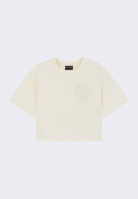 T-shirt raccourci à col rond en coton crème clair avec un motif de cœur texturé sur le côté gauche de la poitrine. Manches courtes, coupe décontractée.