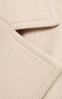 Beige villa kangas, jossa on herringbone-kuvio, taitettu kaulus ja siistit ompelutiedot. Pehmeä ja jämäkkä ulkonäkö.