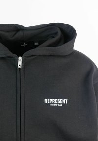 Felpa nera con zip realizzata in tessuto misto cotone. Presenta un cappuccio e un logo ricamato bianco "REPRESENT OWNERS' CLUB" sul petto.
